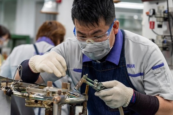 En hantverkare som löder metalldelar med blyfritt lod.