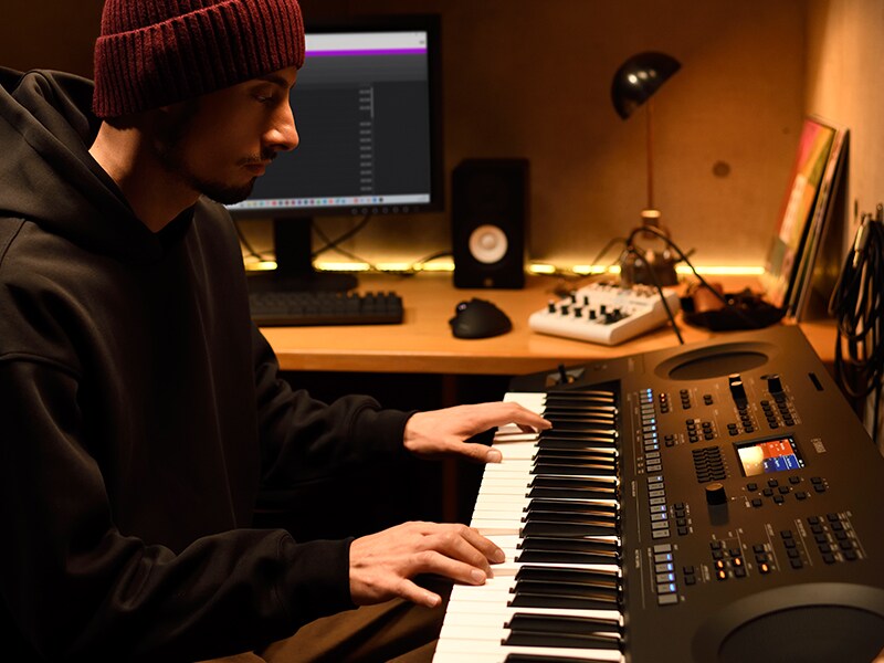 Person som spelar på ett PSR-SX620-keyboard i en hemmastudio.