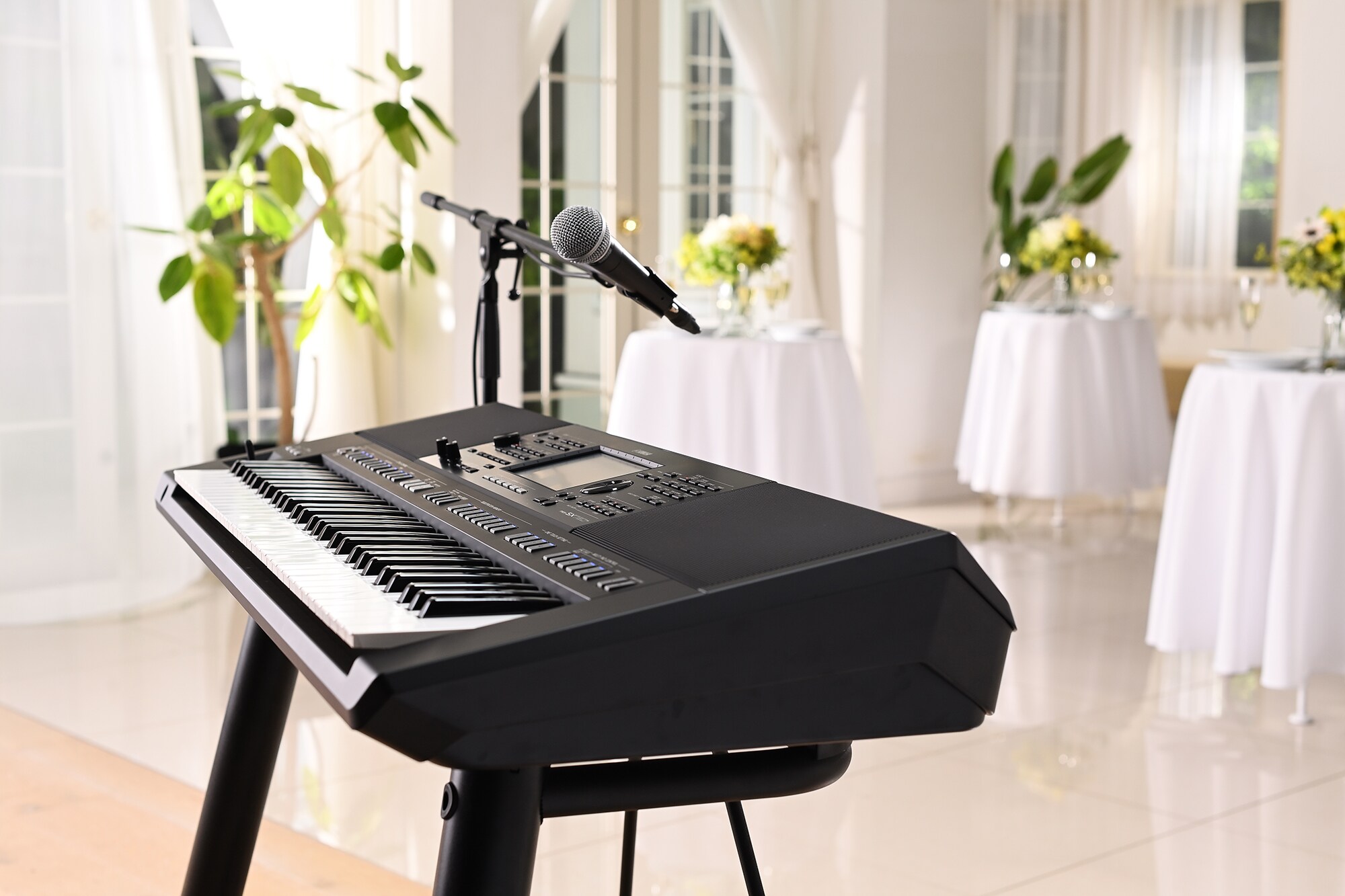 Yamaha Arranger Workstation PSR-SX720+ med mikrofonstativ i en festlokal