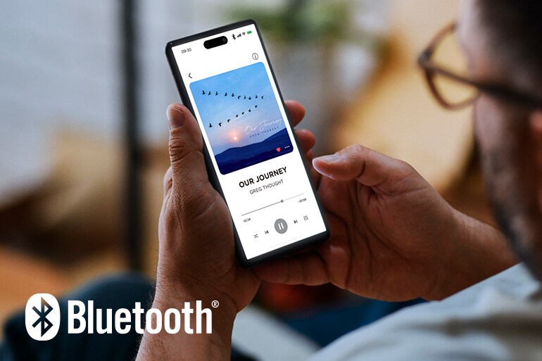 Bluetooth-logotypen och en man som använder en smartphone för musikuppspelning.