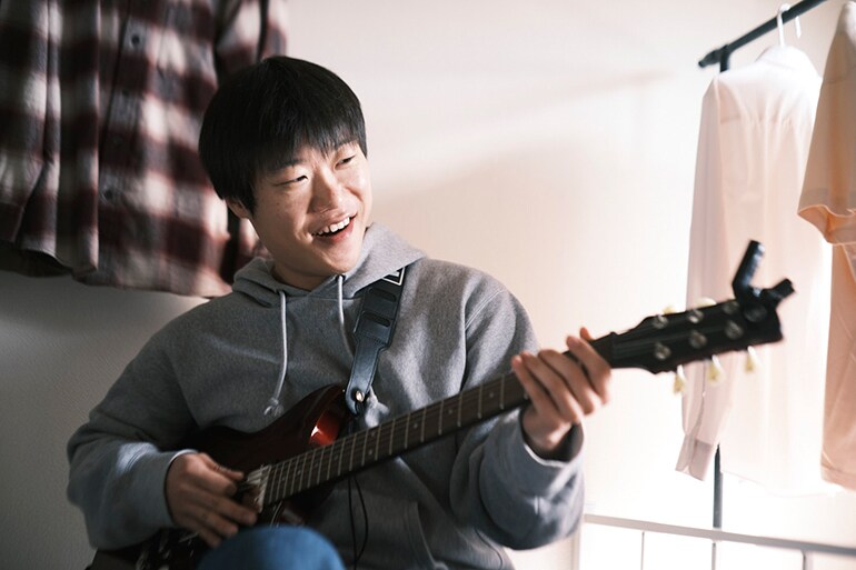 En man som försöker spela gitarr för första gången