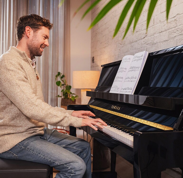En kvinna som spelar på ett upprättstående piano i B-serien