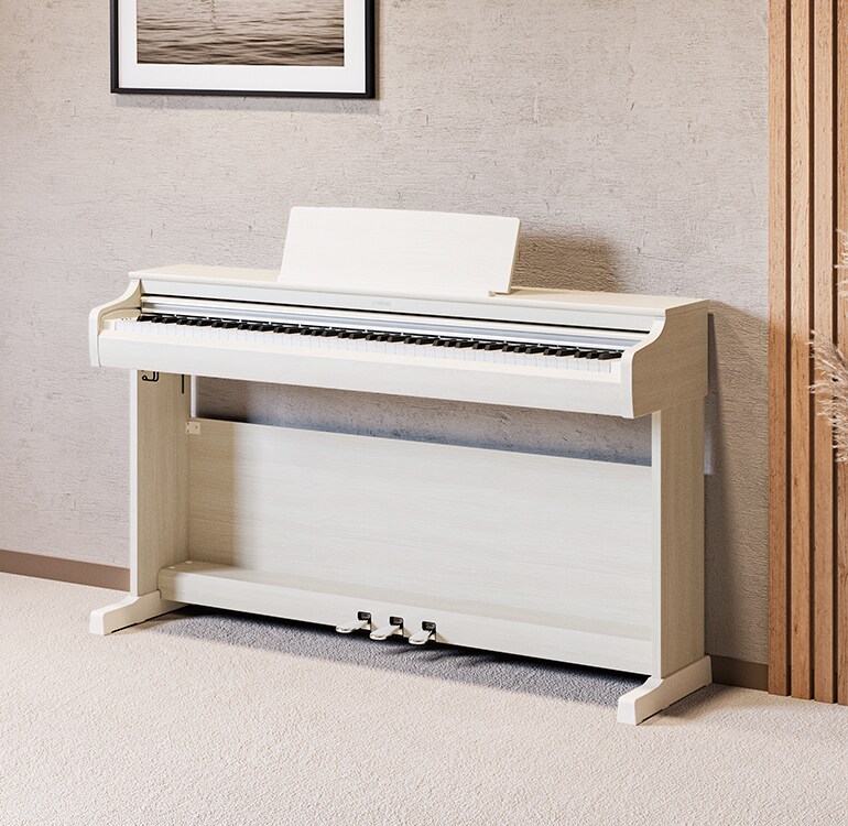 Ett vardagsrum med ett ARIUS-piano i vit björk, krukväxter och en soffa, harmoniskt integrerat med inredningen