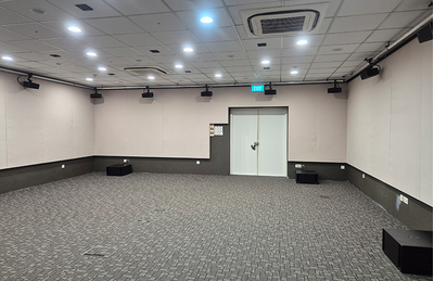 Singapore training facility room with seating, presentation screen, and audio equipment.