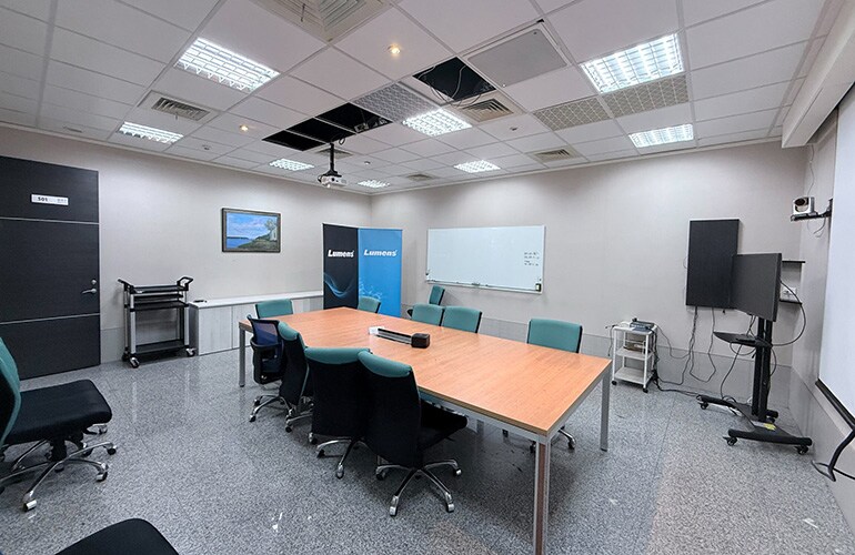 Hsinchu City training facility with meeting table, display screen, and presentation equipment.