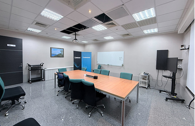 Hsinchu City training facility with meeting table, display screen, and presentation equipment.