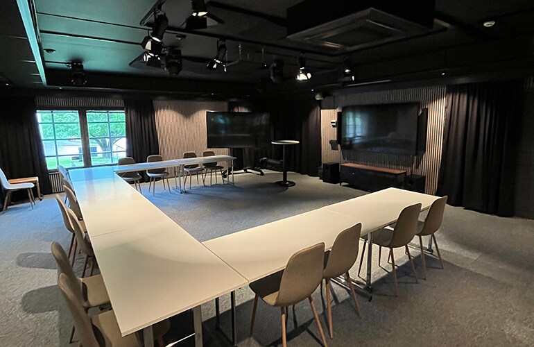 Gothenburg training facility with a large conference table, ceiling speakers, and presentation system.