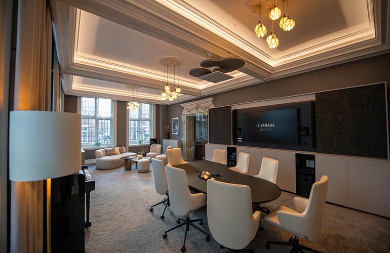 London training facility meeting room with tables, seating, and display screen.