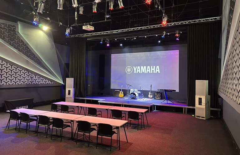 Johannesburg training facility auditorium with Yamaha display screen, stage area, and seating.