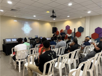 Santo Domingo training facility with attendees seated in a classroom-style audio training session.